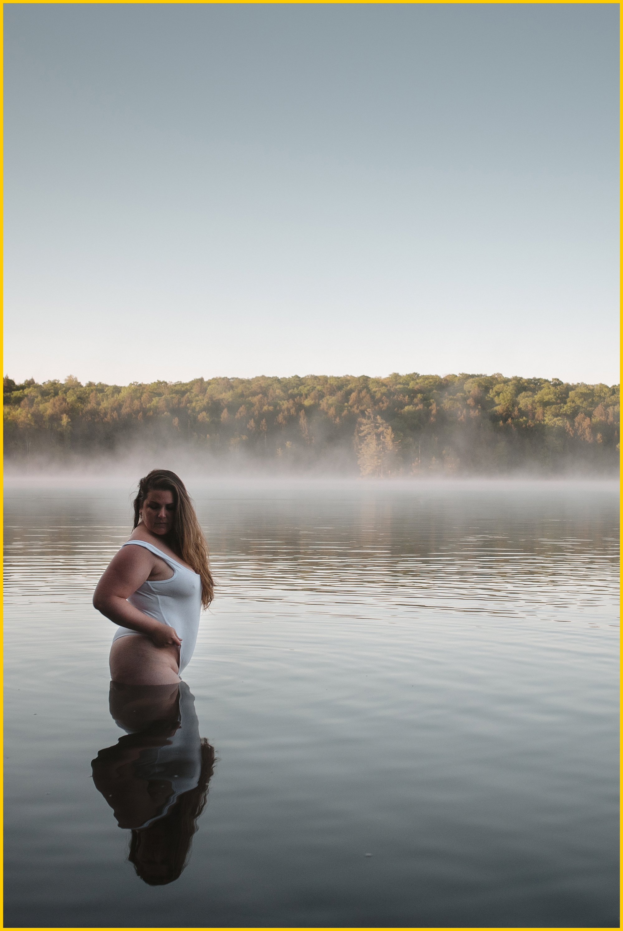 curvy woman posing in a still lake