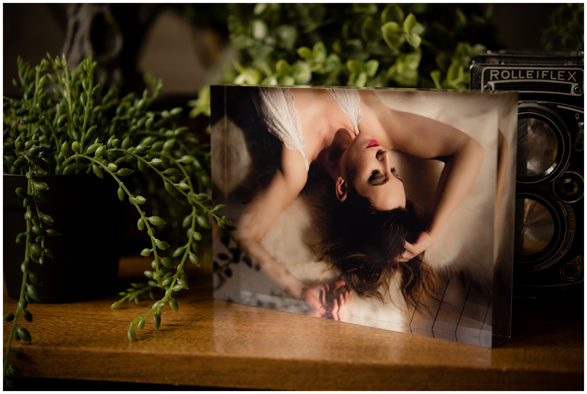 Image shows an acrylic photograph of a nelson bc boudoir session, the woman in the image is laying on her back with her arms laying above her head