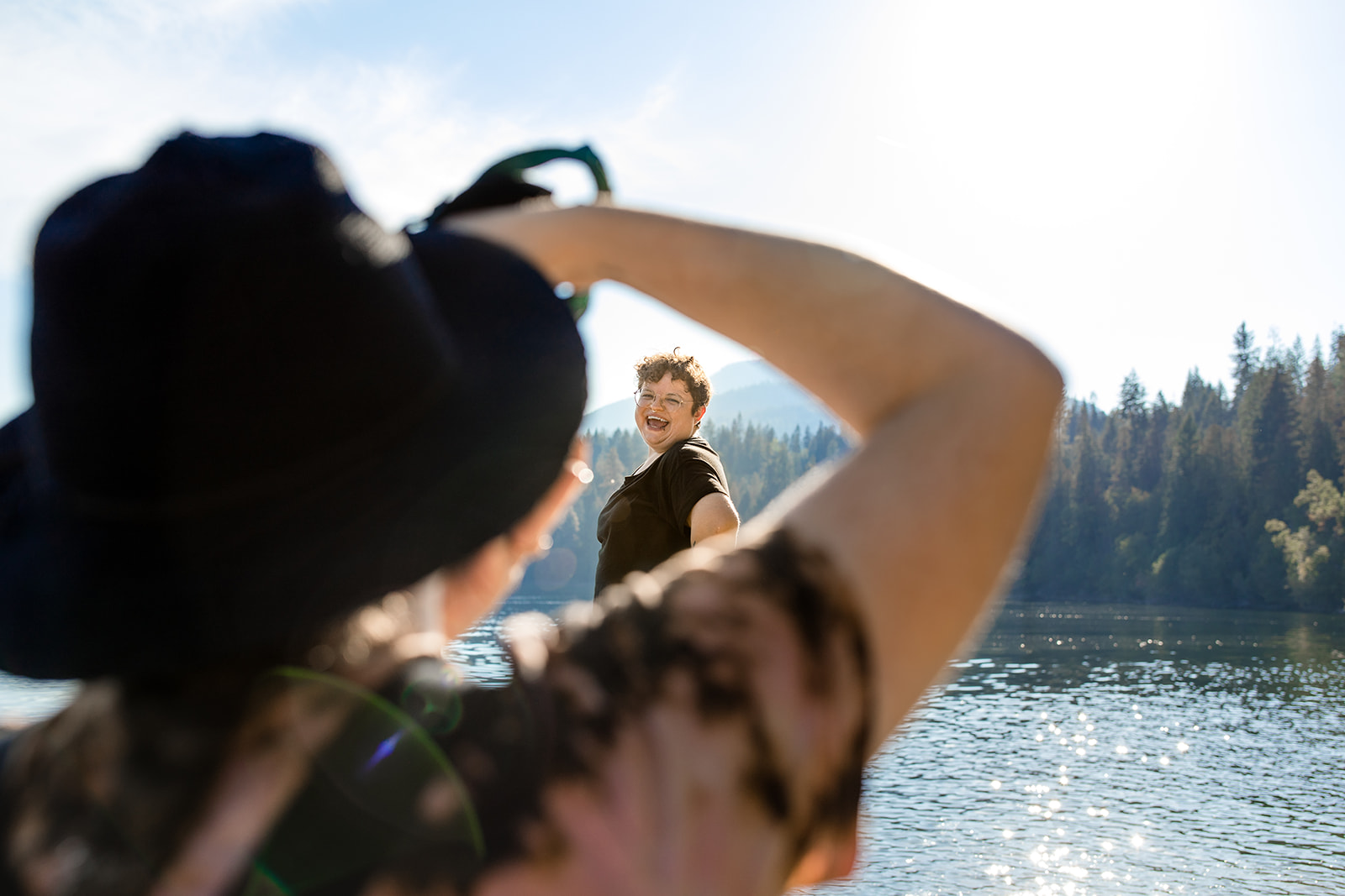 Erika Broom, a photographer with The Babes Club, takes a photograph of a client during an outdoor empowerment photography session in the kootenays in british columbia